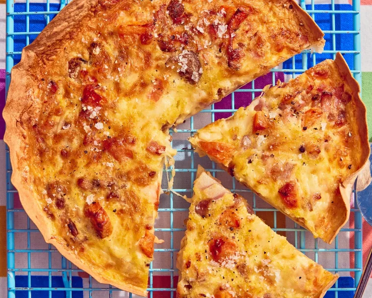 tortilla omelette with slice cut out of it on blue cooling tray