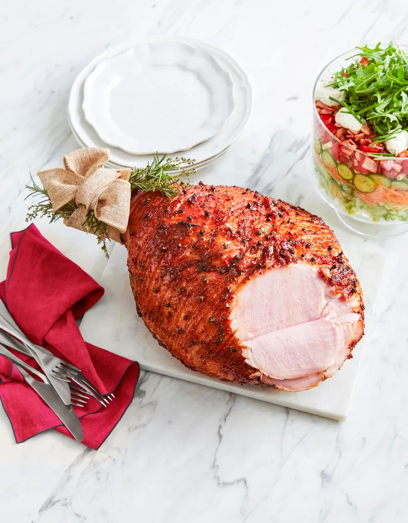 honey mustard ham with christmas tie on the end with layered pasta salad in trifle stand on the side