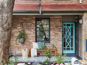 front of house with painted stencilled floor in blue and aquaa. Aqua painted front door