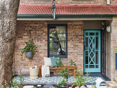 front of house with painted stencilled floor in blue and aquaa. Aqua painted front door