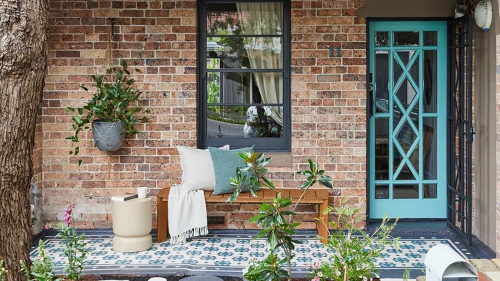 front of house with painted stencilled floor in blue and aquaa. Aqua painted front door