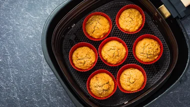 7 cooked muffins in an air fryer lined in a silicone baking cup