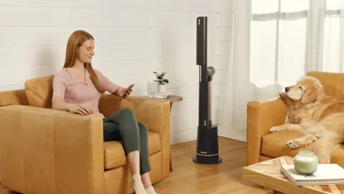 Woman sitting in an armchair with a charcoal Shark TurboBlade Ultra bladeless fan next to her chair