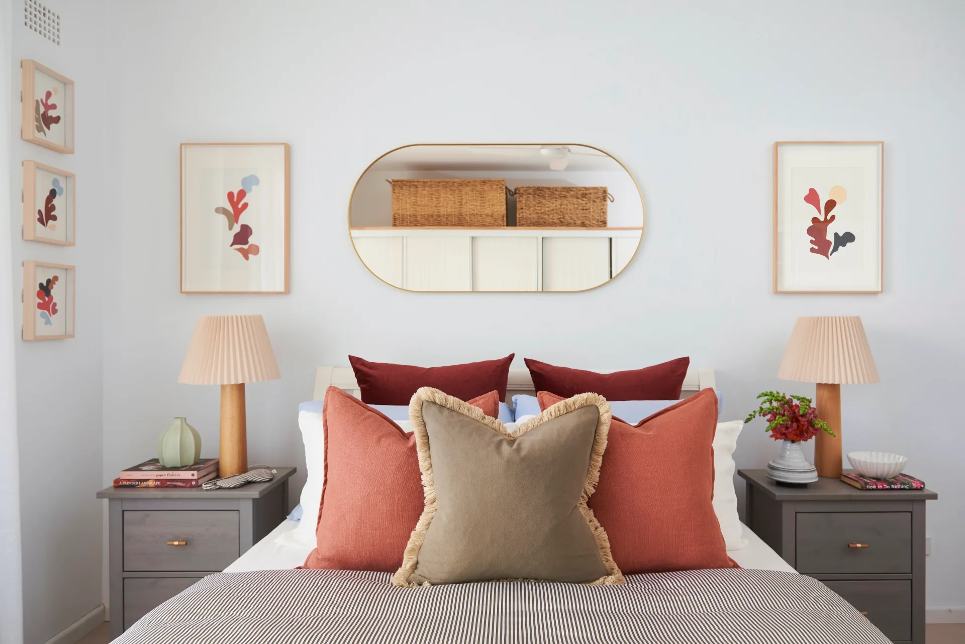 bedroom with bed and mirror, pink and brown cushions