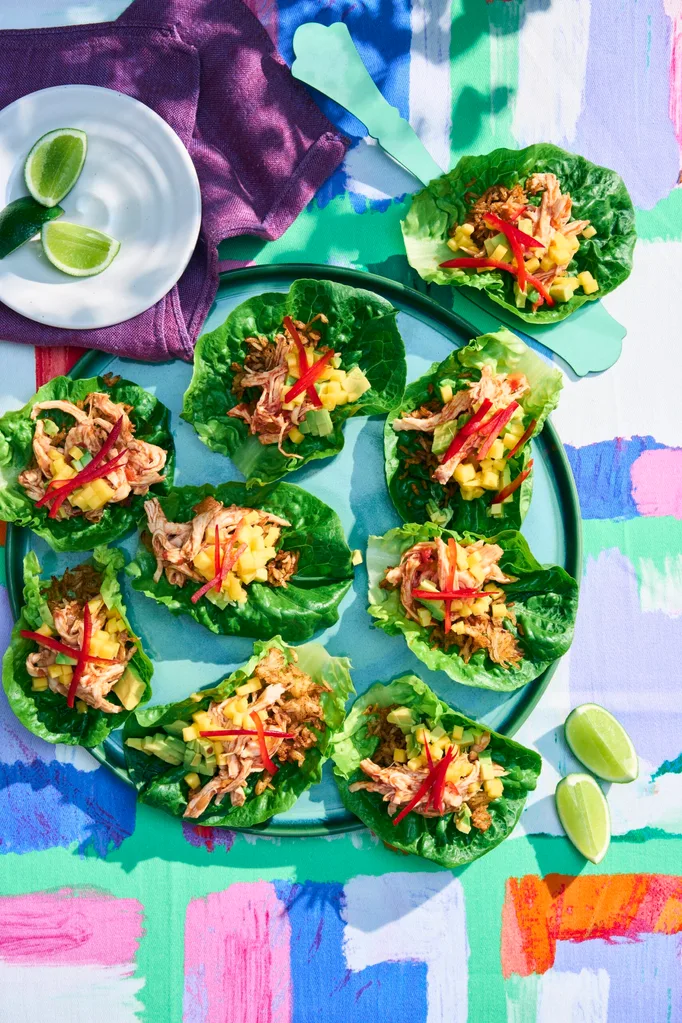 chicken lettuce cups with mango salsa on a green plate and colourful table cloth