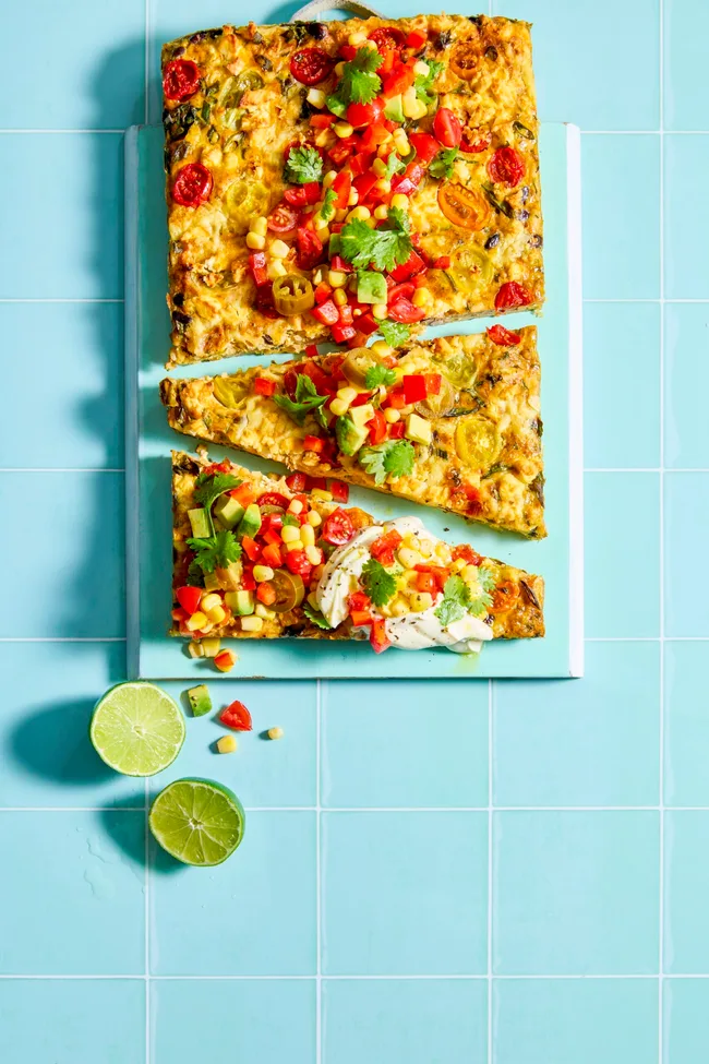 cheesy mexican slice on a blue board with lime wedges