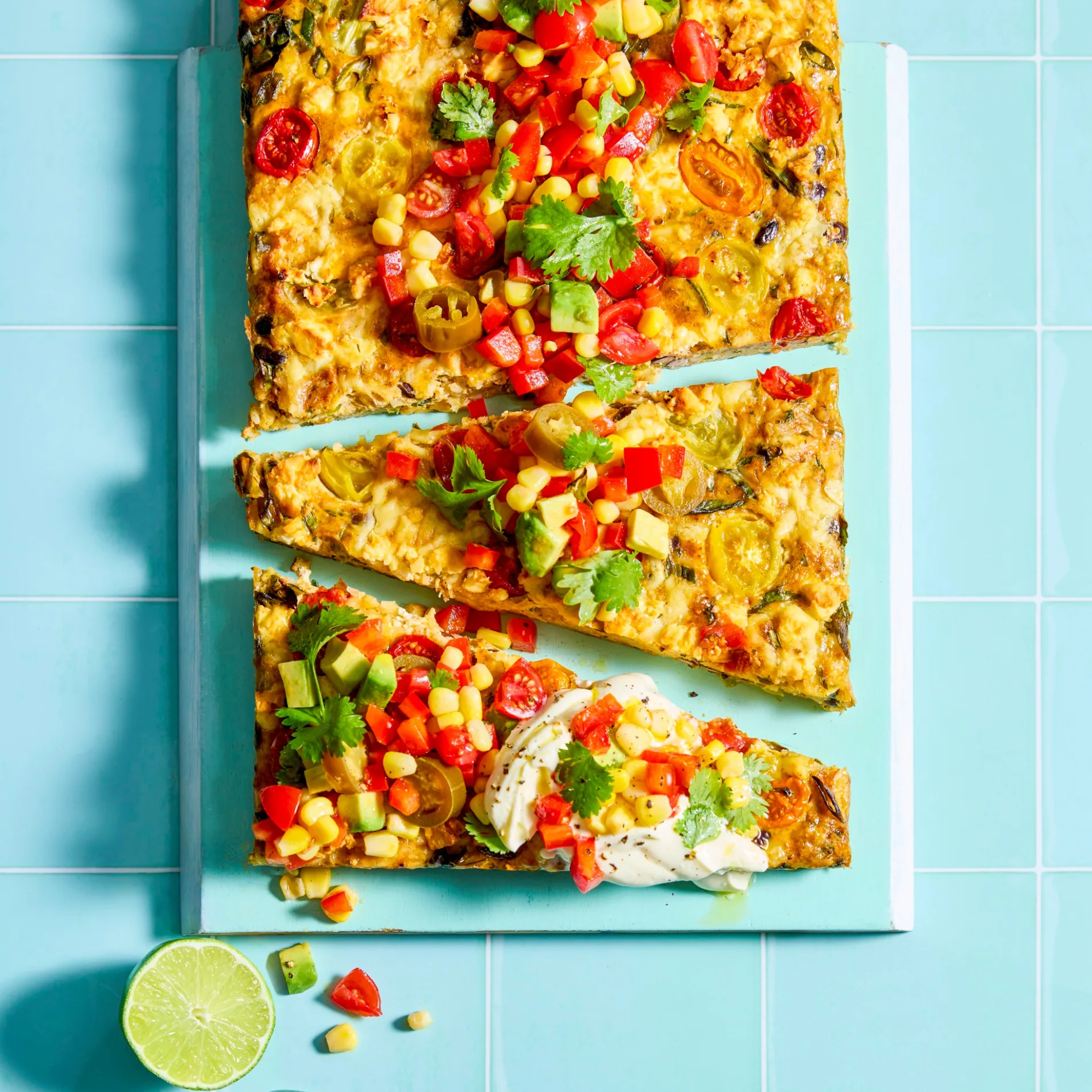 cheesy mexican slice on a blue board with lime wedges