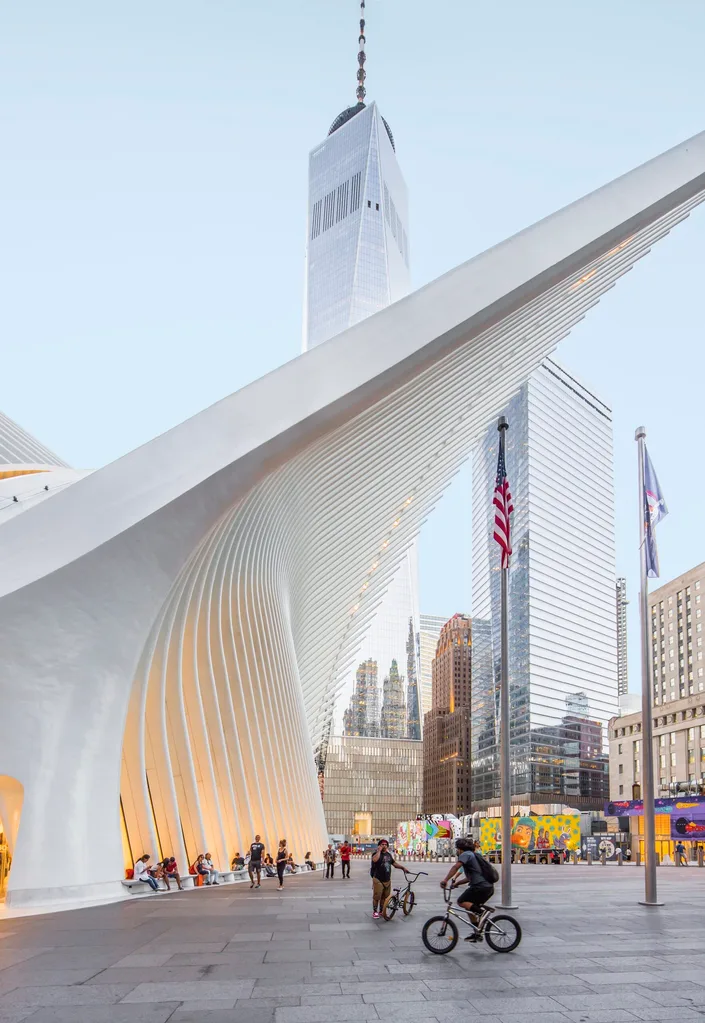 image of the world trade center in new york with people sitting and biking in front