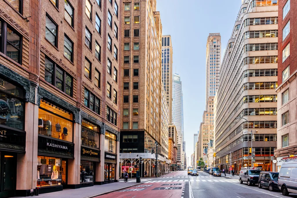 new york fifth avenue with cars on street and fancy shops