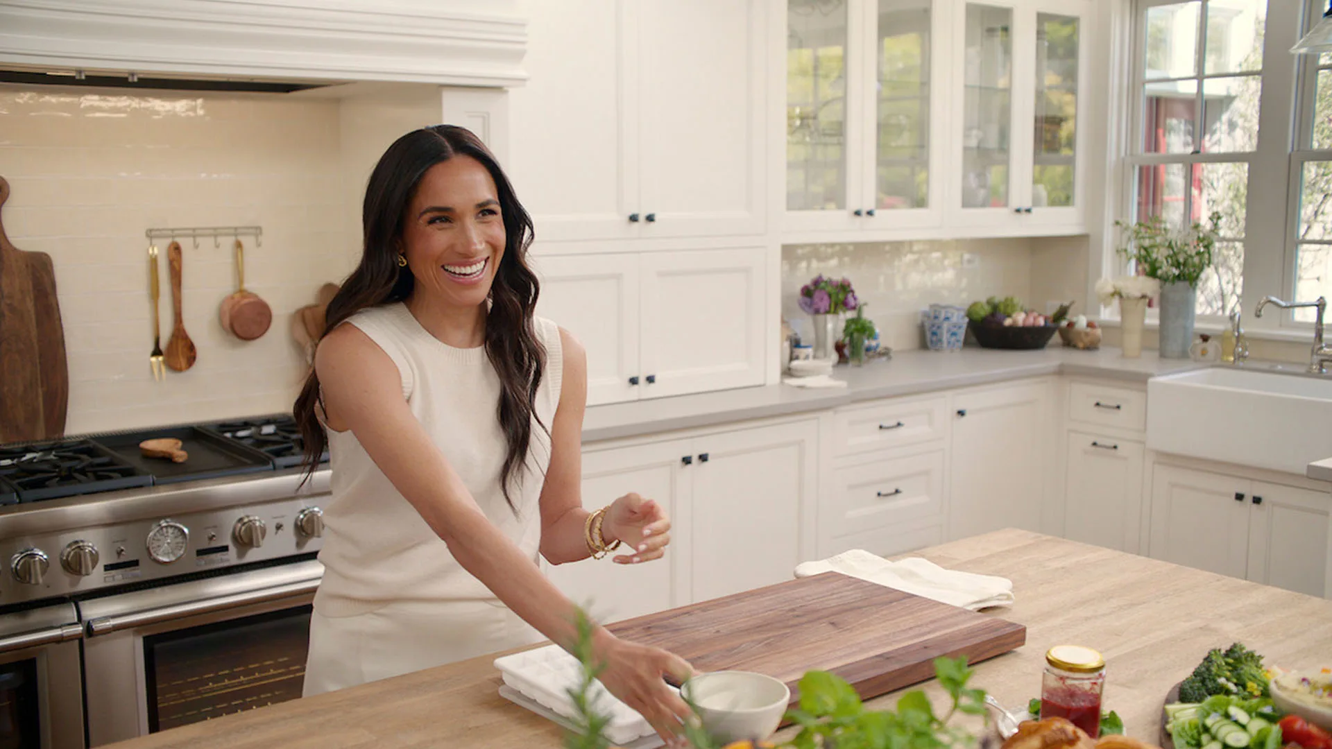 Meghan Markle in a white kitchen smiling in new Netflix series, With Love, Meghan