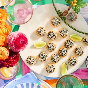 prawn toast on a white plate and colourful table cloth