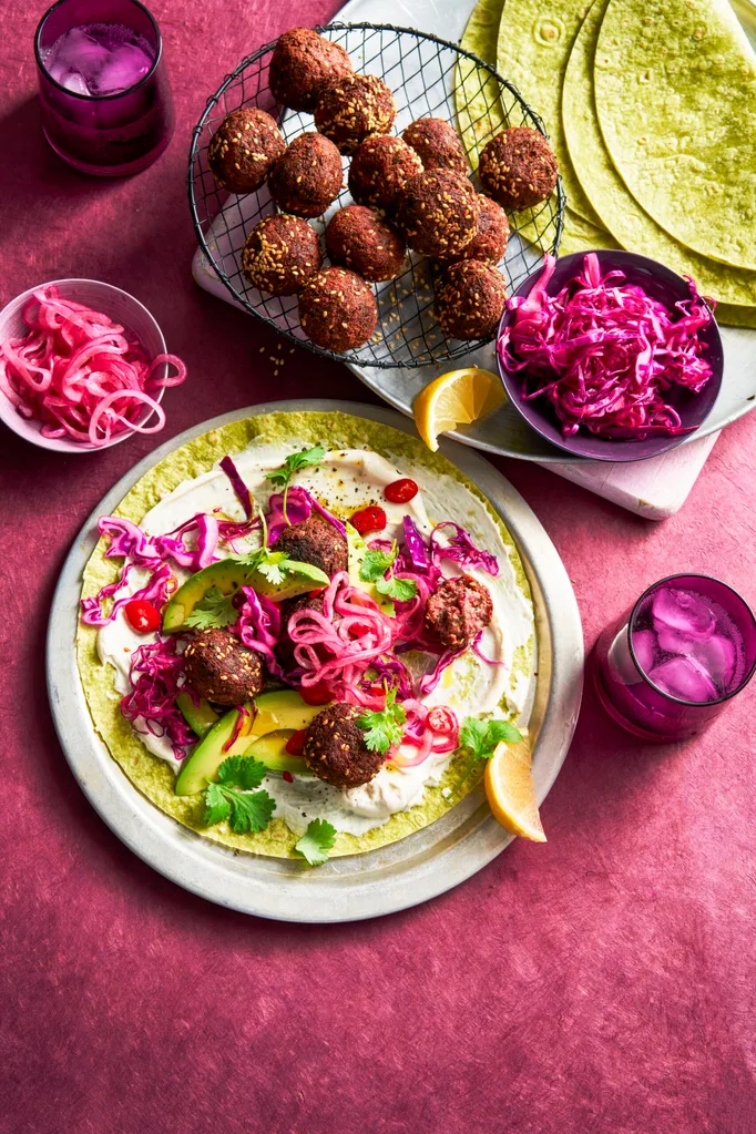 open wrap with purple pickled onion and beetroot on top of falafel