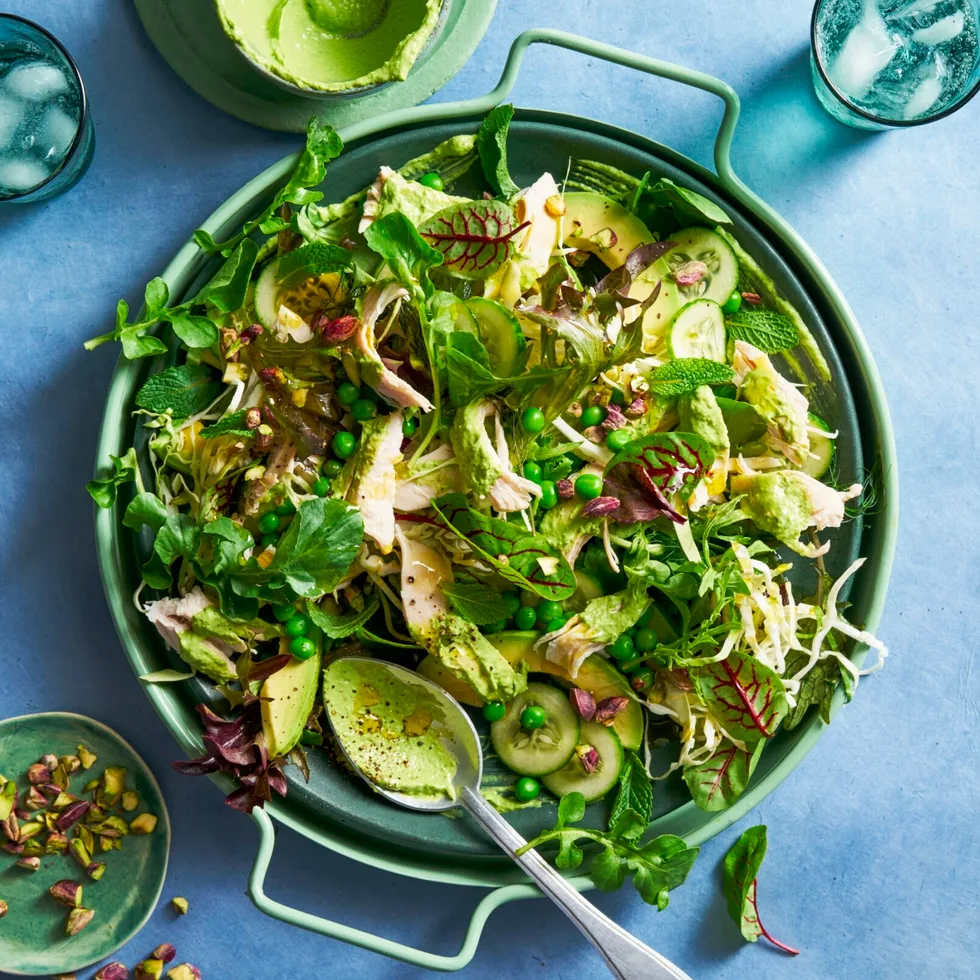 green salad with peas and salad with spoon sticking out and handle bowl