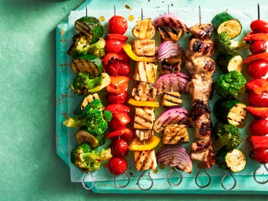 vegie skewers with tofu and meat on them in a line resembling rainbow colours