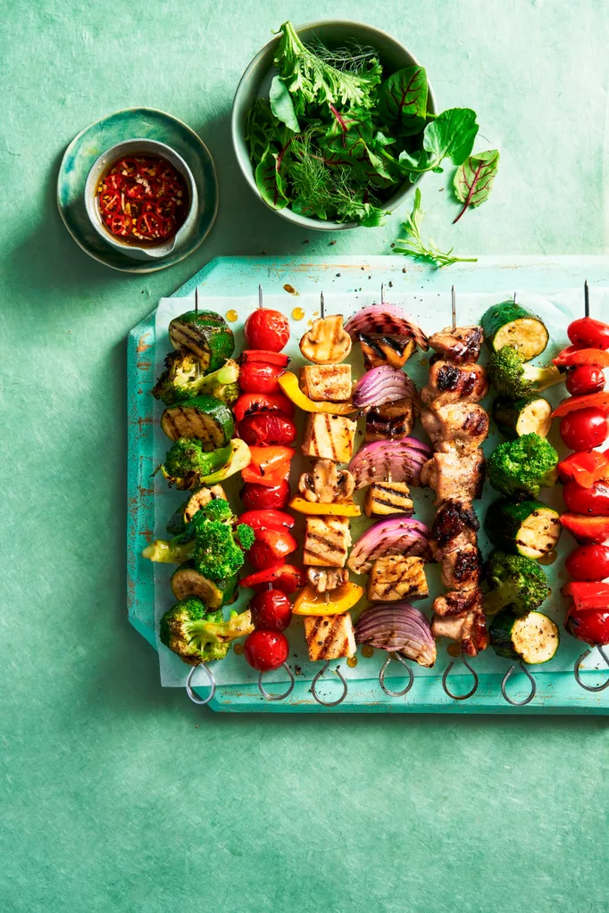 vegie skewers with tofu and meat on them in a line resembling rainbow colours