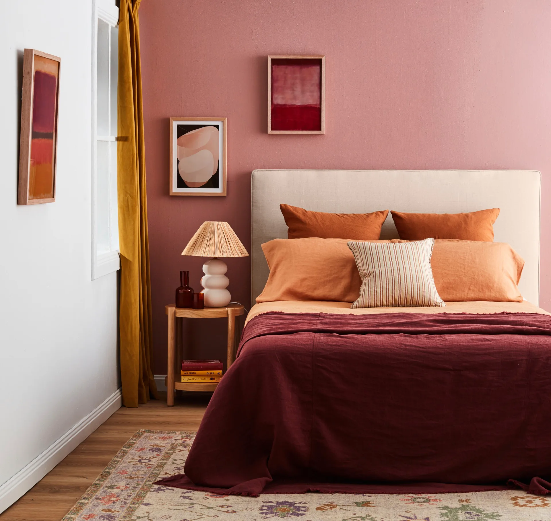 pink painted room with fancy artwork mustard yellow curtains and bedroom decorating ideas for a bold colour drenching style