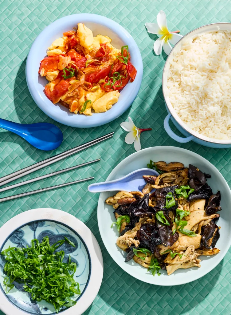 mushrooms in one bowl and tomato and egg stir fry in another bowl with greens on the side