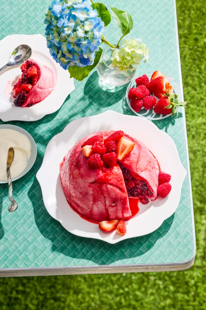 summer pudding bright pink colour on blue table with grass on the floor