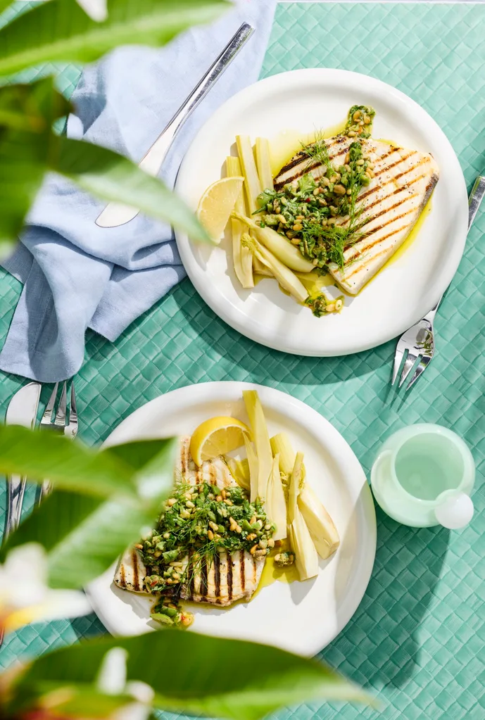 swordfish steaks with pickled fennel on white plate with blue tablecloth