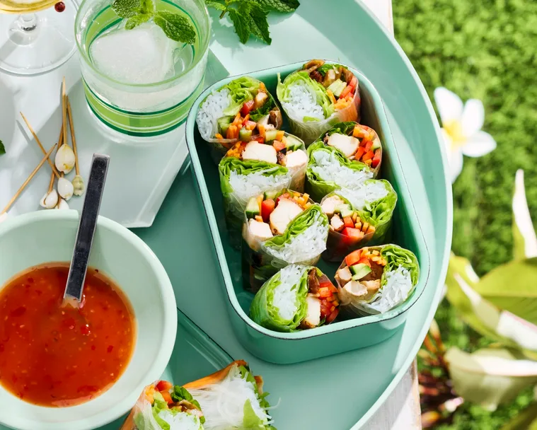 chicken teriyaki rolls in lunchbox with bowl of sauce next to it