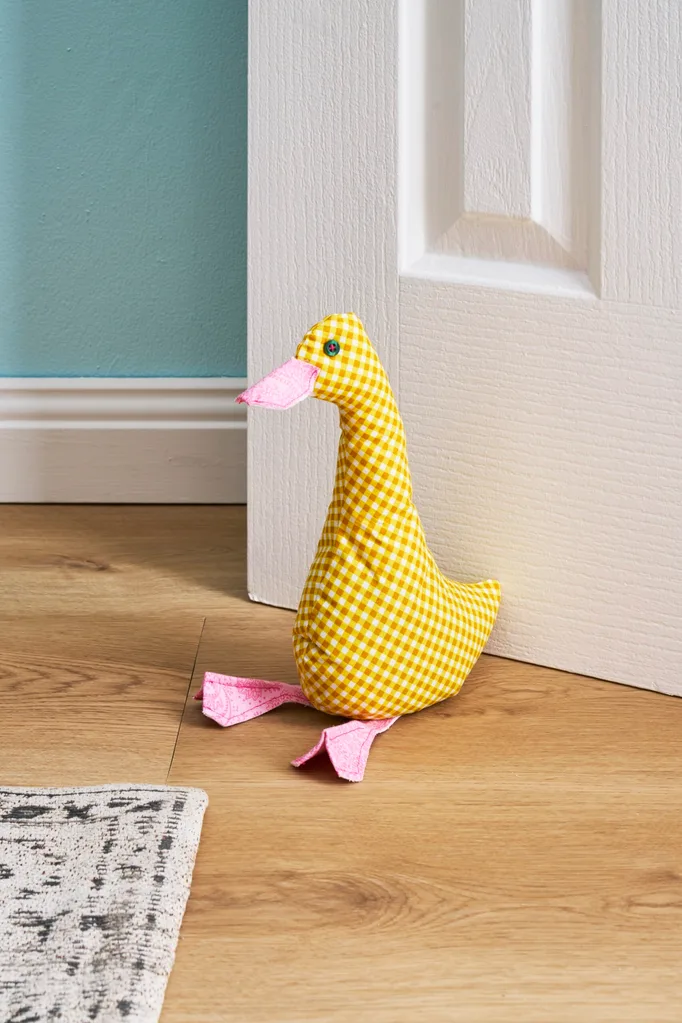 duck doorstop in yellow holding door open