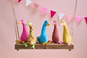 duck doorstops made of fabric on hanging swing with bunting behind