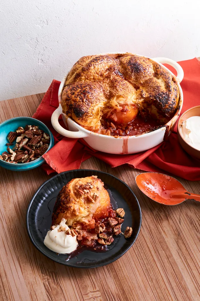 big peach and pecan pie in white dish with large mounds of pastry on top