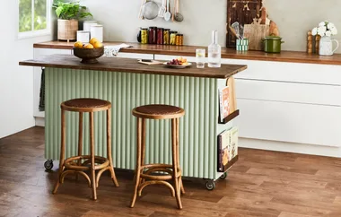 green kitchen island with wooden stools floor and benchtop kitchen setting