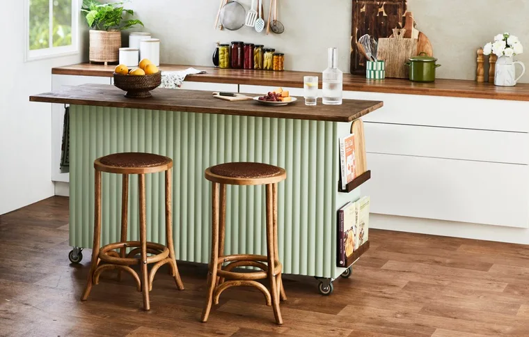 green kitchen island with wooden stools floor and benchtop kitchen setting