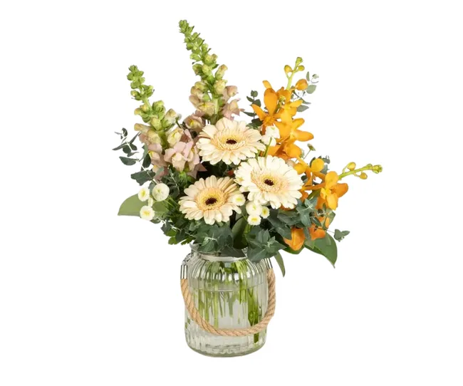 bunch of autumnal inspired flowers in vase with yellows oranges
