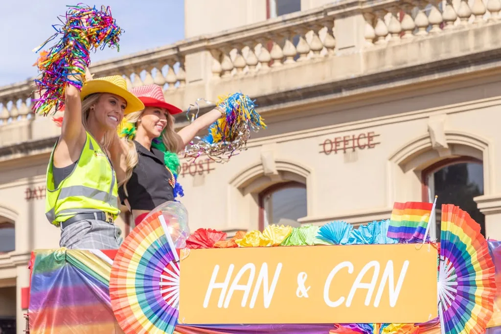 Han and Can contestants on The Block 2025 on a parade float in Daylesford