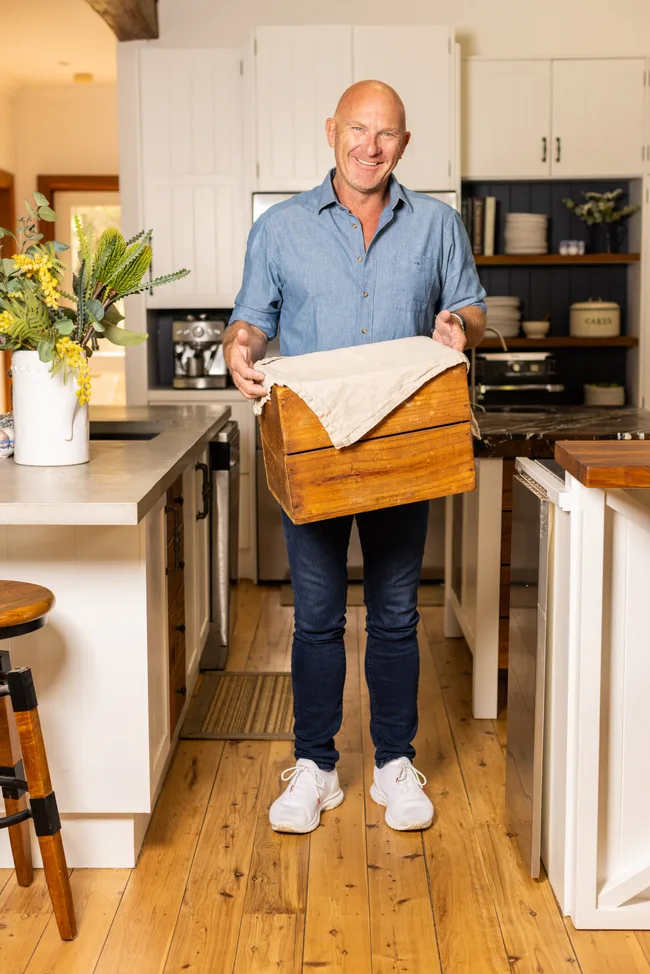 matt moran chef holding mystery box with tea towel over the top in kitchen