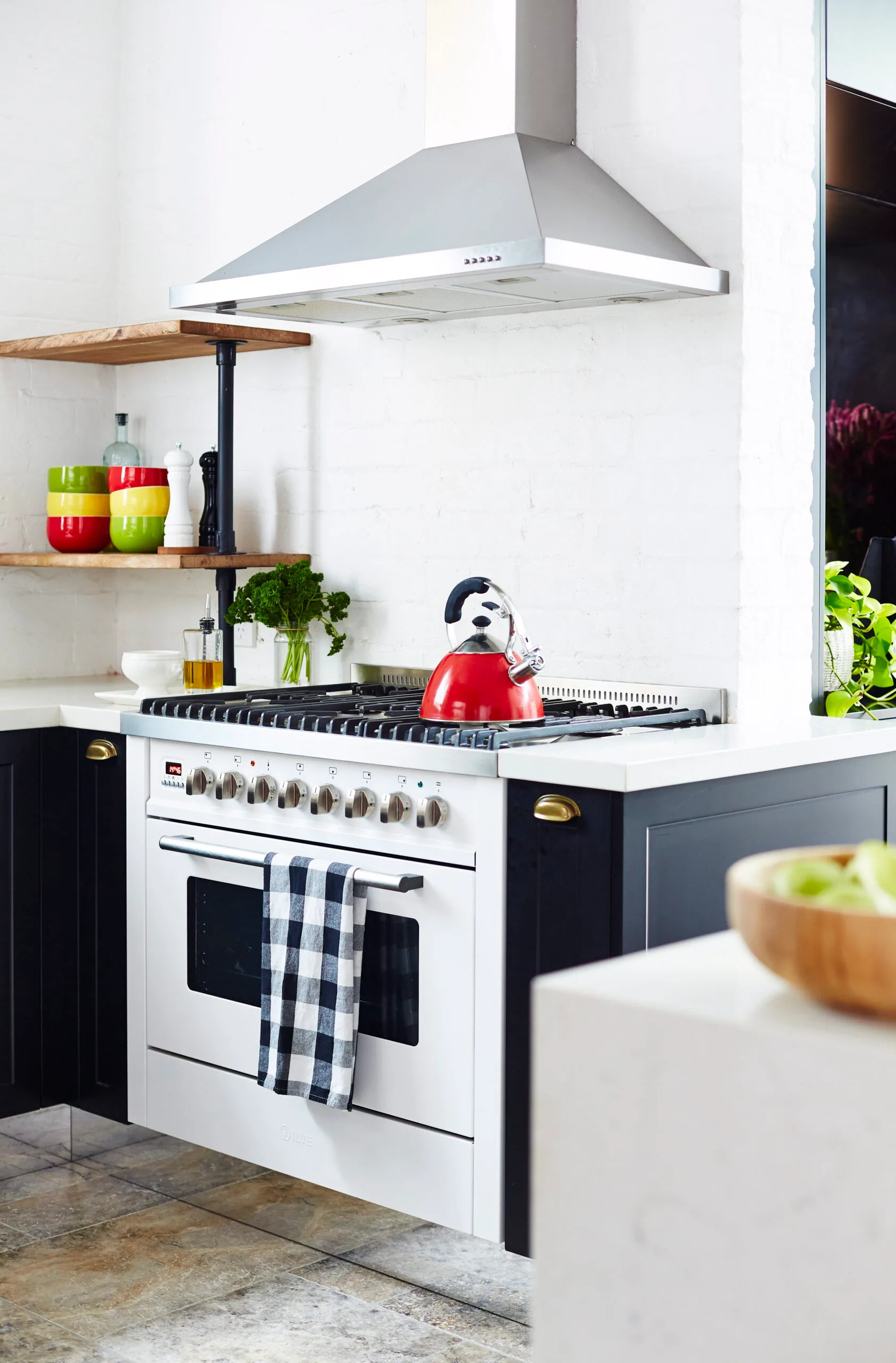 Modern farmhouse kitchen with freestanding white stove and oven and exposed rangehood.