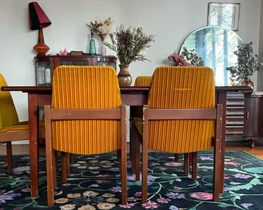dining room table with wooden table, green ruggable rug and yellow chairs