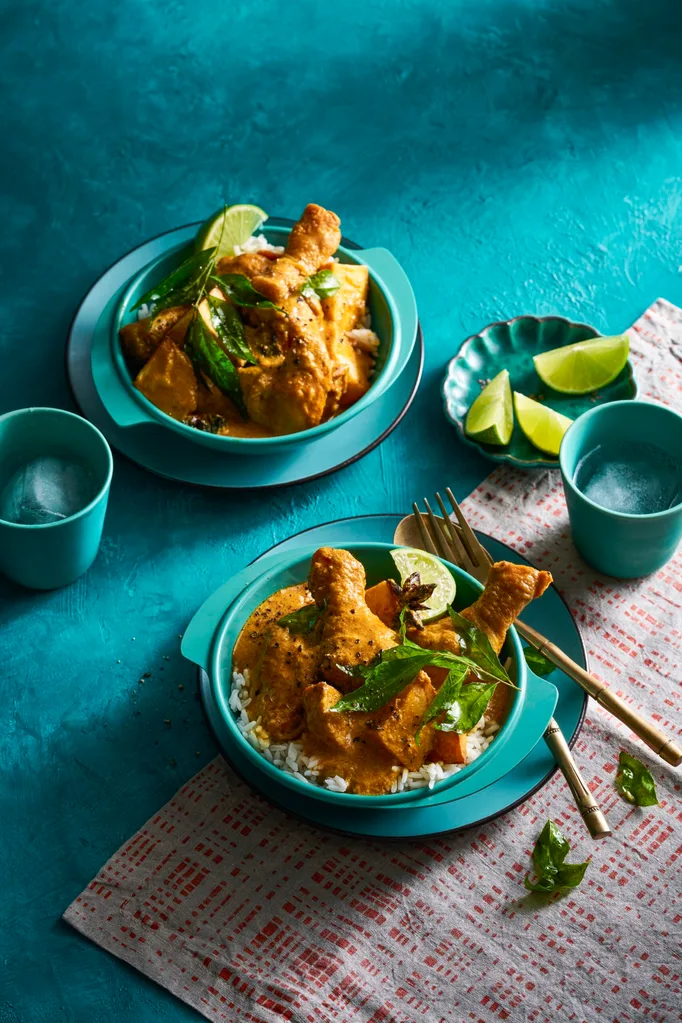 chicken curry in two bowls orangey colour with blue and teal colouring of bowls