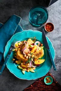 crumbed barramundi on blue plate with bush salad surrounding it