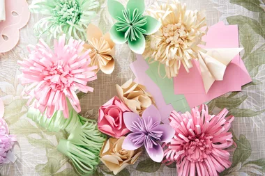 how to fold paper flowers with pink green and purple pastel folded flowers on craft table