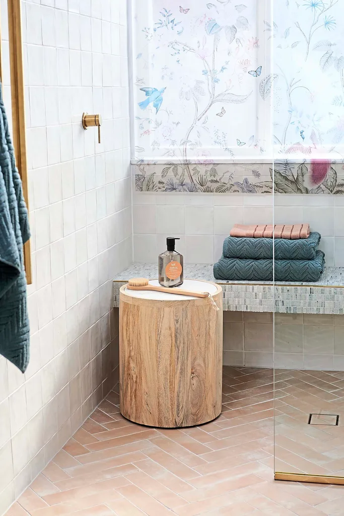 Shower with pink floor tiles and bench seat inside