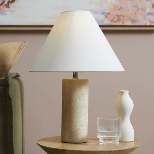 bedside lamp with vase and glass of water next to it
