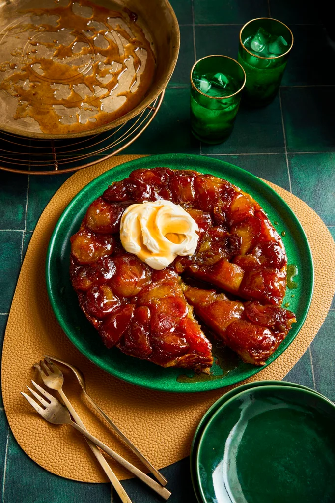 apple tarte tatin with dollop of double cream on top in green bowl