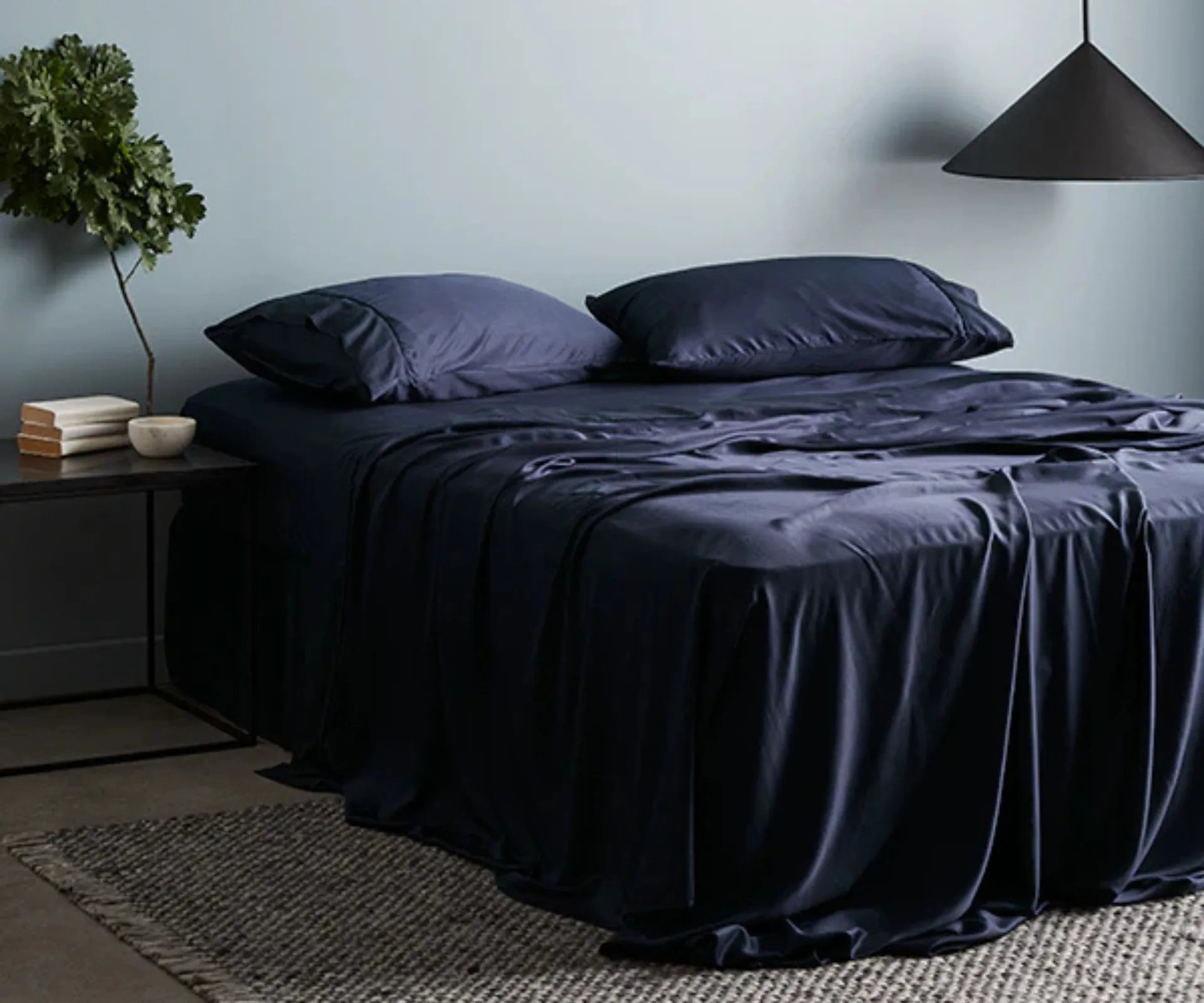dark navy sateen sheets and pillows on a queen bed