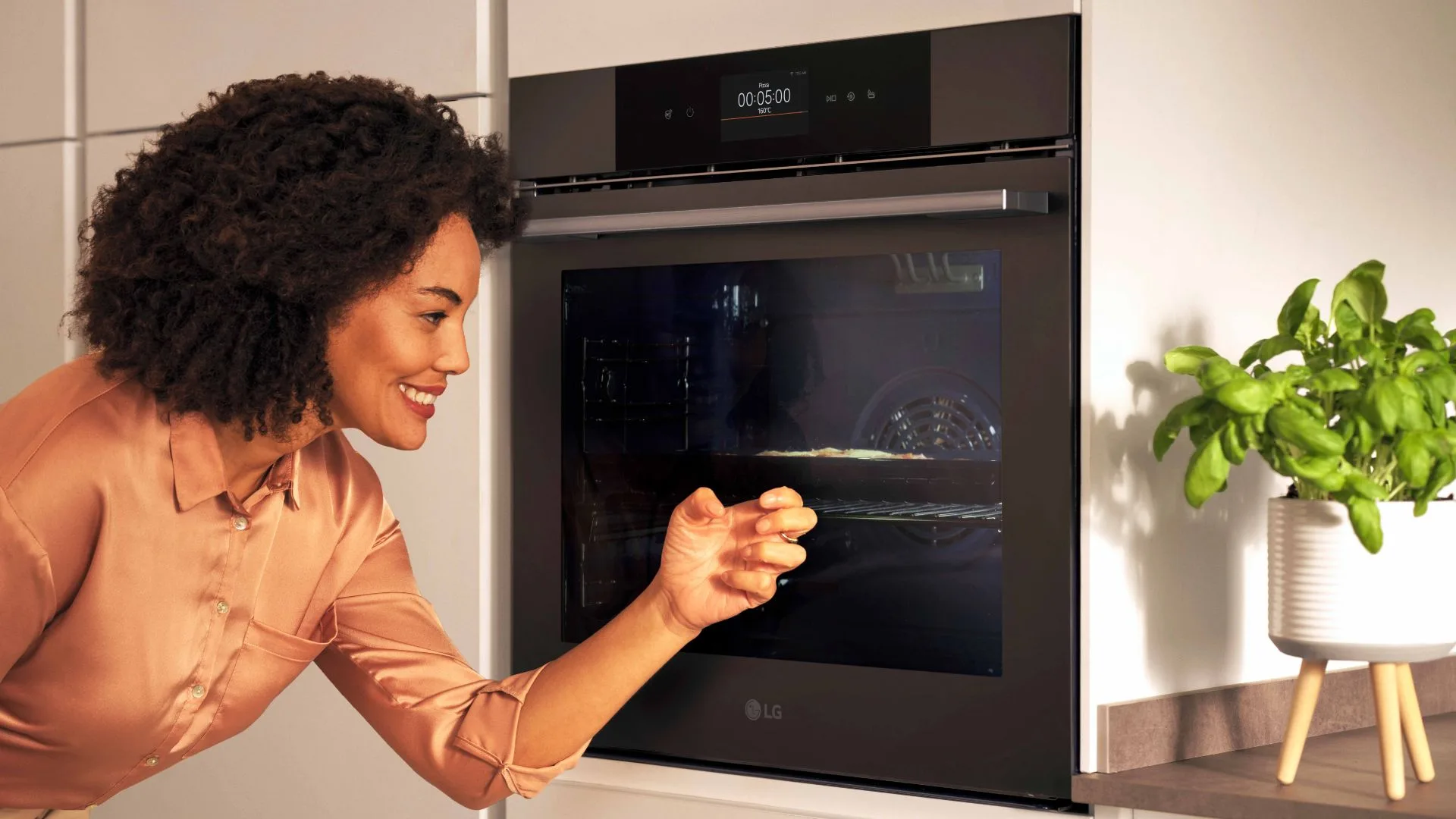 female knocking on glass door of LG oven in kitchen setting