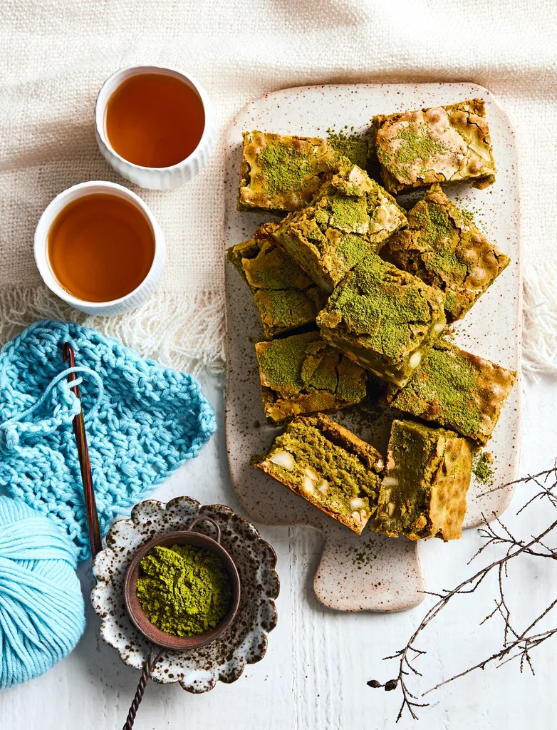 brownies piled on plate with dusting of green matcha on top