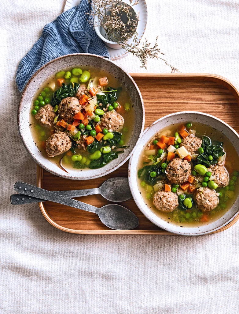 pearl barley stew with chicken dumplings peas and carrots floating in it