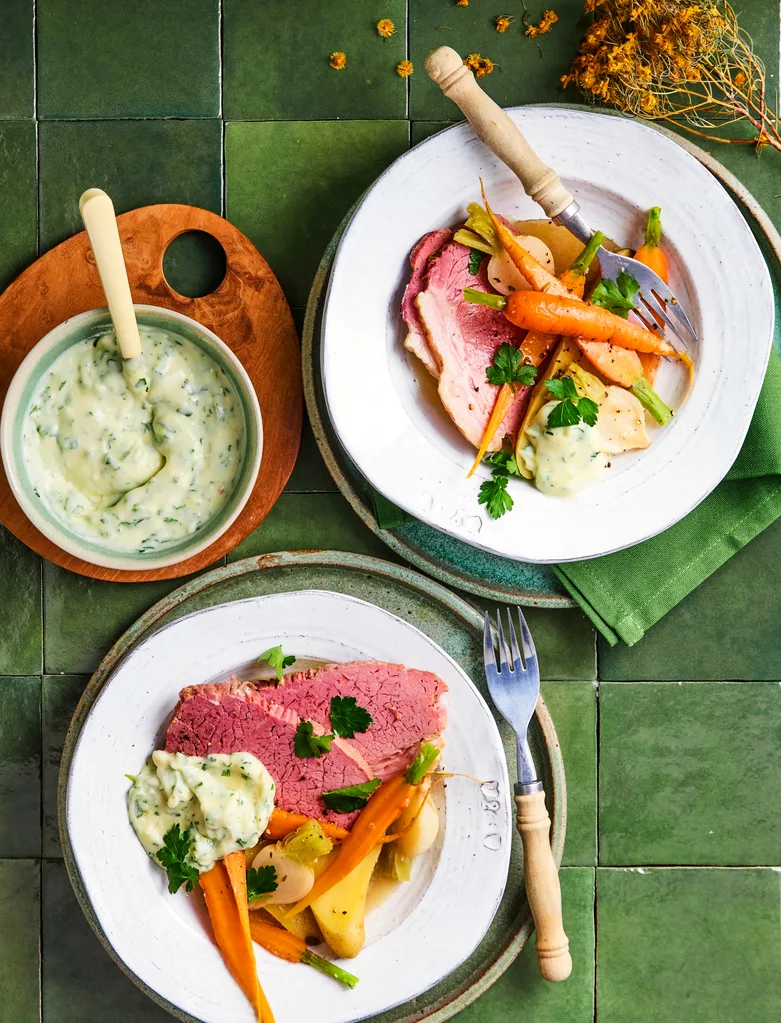 corned beef with carrot in bowl with white sauce drizzled on top