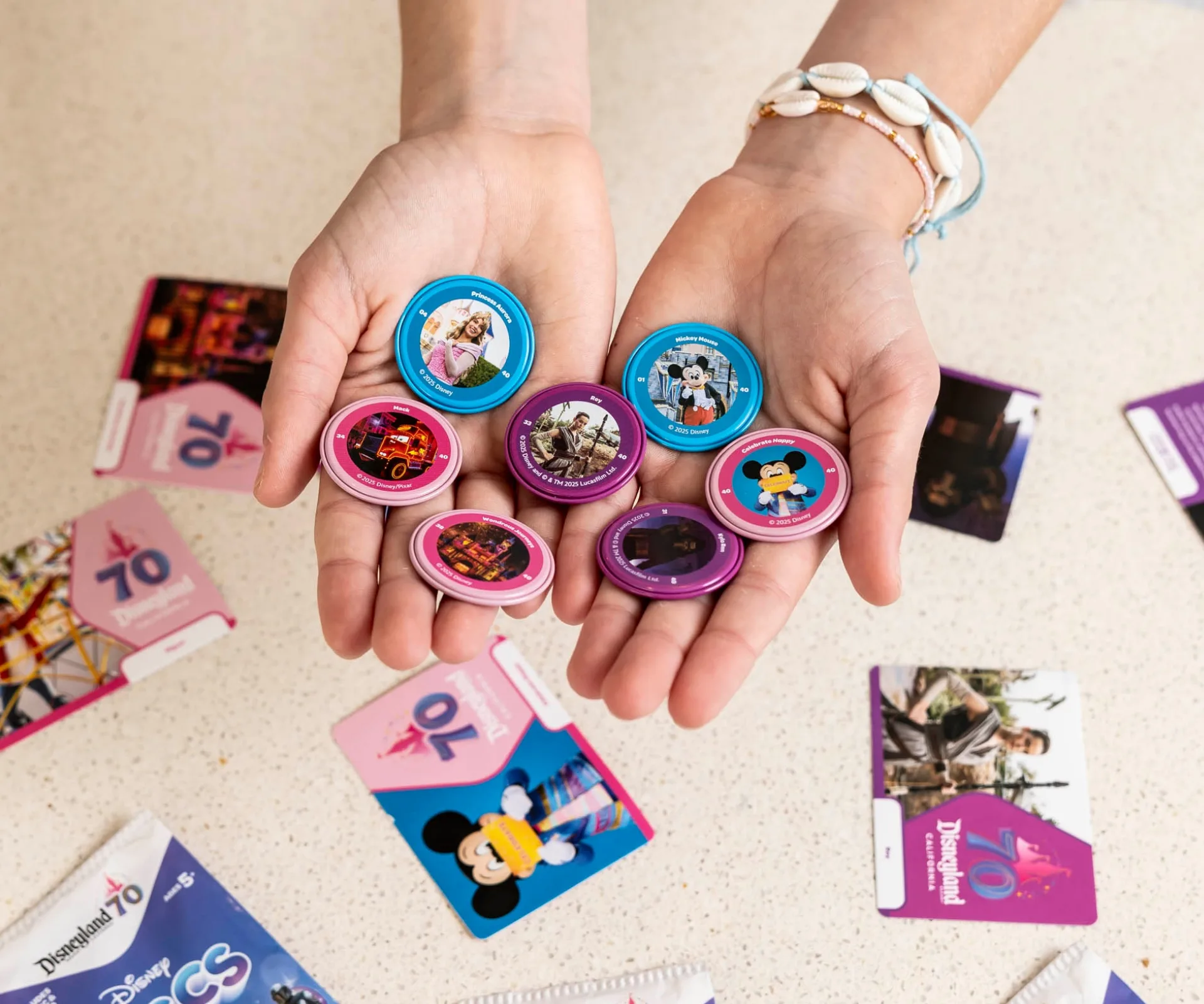 A pair of hands holding a selection of Disney Discs, a limited edition collection available at Woolworths.