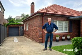 scotty cam standing outside standard brick aussie home with chimney and driveway. scott cam going though his home maintenance checklist
