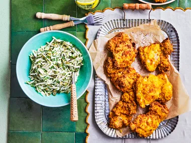 fried chicken on square rounded plate with bowl of slaw on the side