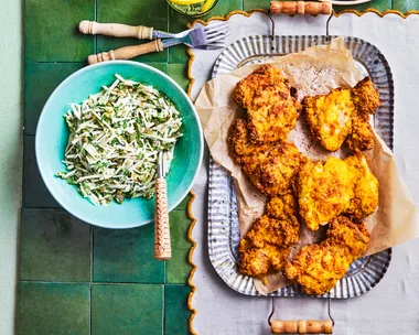 fried chicken on square rounded plate with bowl of slaw on the side