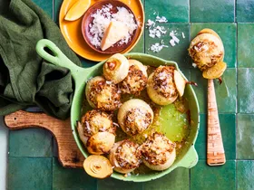 stuffed onions in fry pan that's green and parmesan sprinkled on top